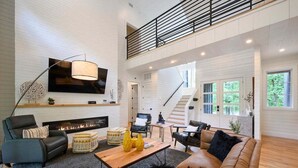 A spacious living room with a fireplace, a large flat-screen TV, and a staircase leading to an upper level. - 2 Slides Off Deck, Foosball, Hot Tub, Pets, Let It Slide (Broken Bow)
