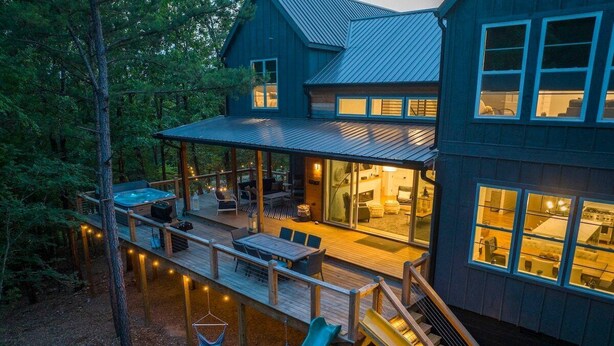 A modern house with a deck, outdoor seating, and a slide. - 2 Slides Off Deck, Foosball, Hot Tub, Pets, Let It Slide (Broken Bow)