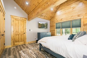 A bedroom with a wooden ceiling, a bed with white bedding, a blue dresser, and a window with blinds. - Foxcroft: Lake Access, Hot Tub, Game Room, Pool Table, Dogs OK (Oakland)