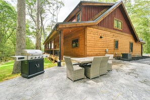 A log cabin with a patio, outdoor grill, and wicker furniture. - Foxcroft: Lake Access, Hot Tub, Game Room, Pool Table, Dogs OK (Oakland)
