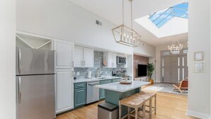 A modern kitchen with a skylight, stainless steel appliances, and a central island with bar stools. - The Brazo - Central Downtown Cincinnati - walk to stadiums (cincinnati)