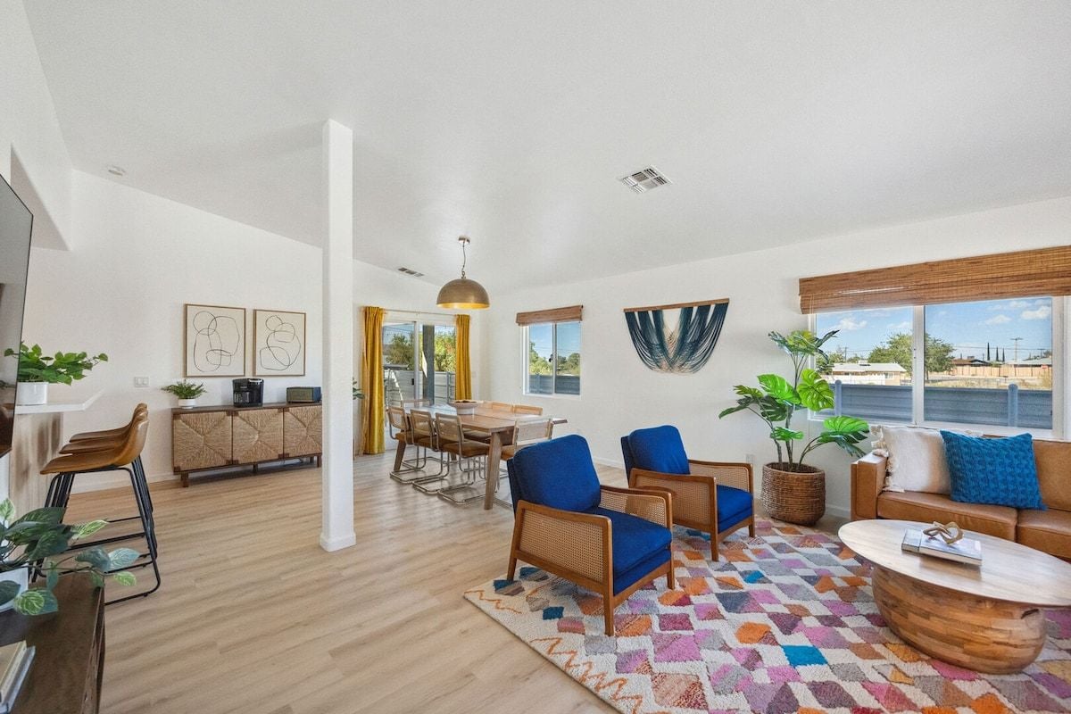 Un salon moderne avec un plancher en bois, un coin repas et une vue sur la mer.