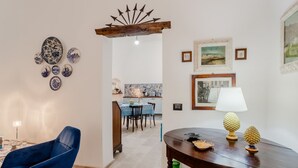 A dining area with a table, chairs, and decorative items. - GuestHost - Albachiara Home in Andria (Andria)