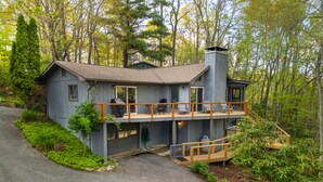 Une maison à deux étages avec un balcon, un garage et une cheminée.