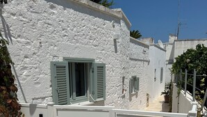 A white building with a gate labeled "Montesanto 60". - Charming suites among trulli in the heart of Alberobello (Alberobello)