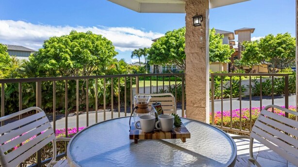 A covered outdoor seating area with a table, chairs, and a grill.