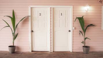 Two doors labeled 1 and 2, flanked by potted plants, with a light fixture above door 1.