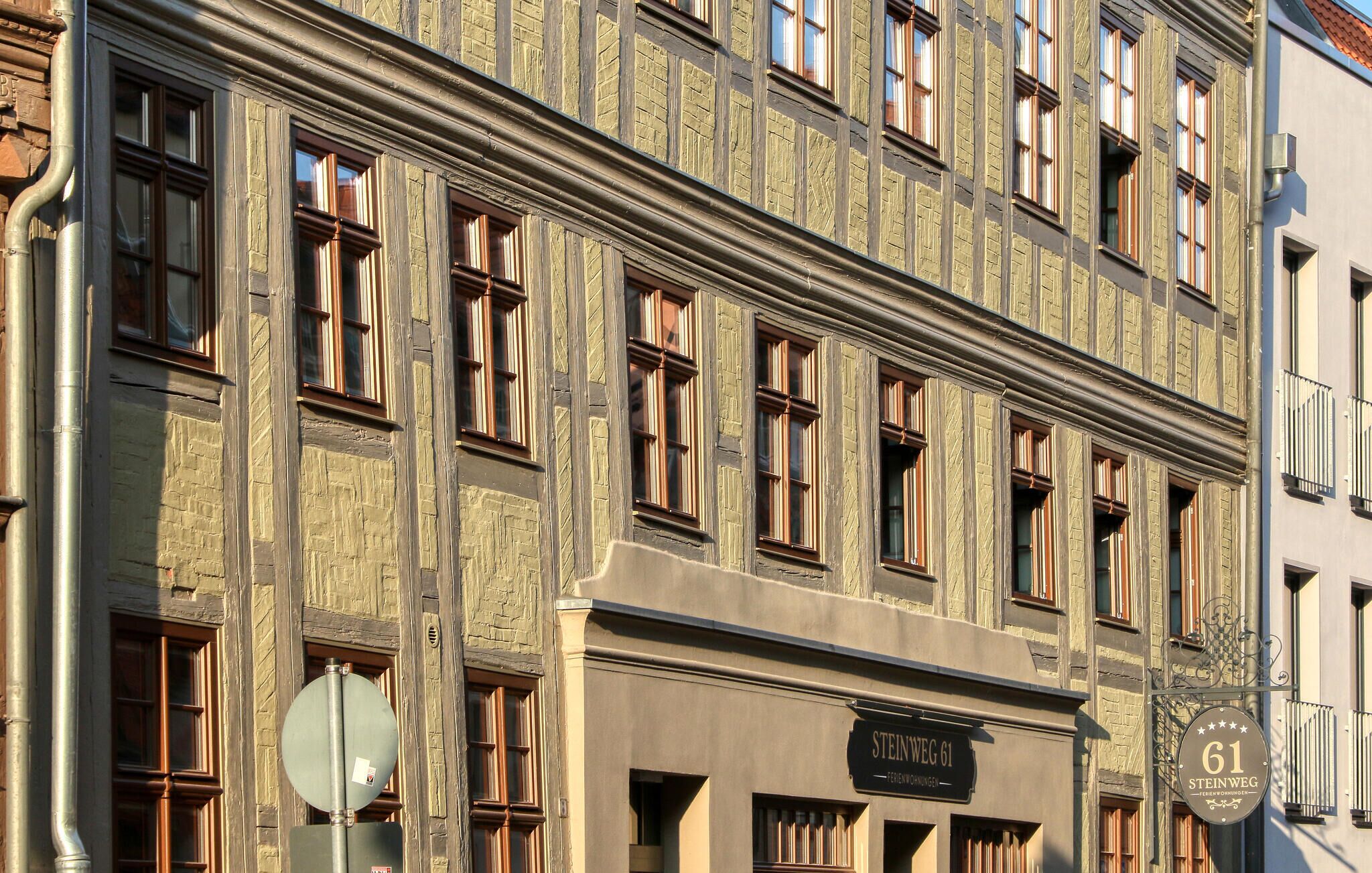 Monikerroksinen rakennus, jossa on kyltti, jossa lukee »STEINWEG 61» ja »FERIENWOHNUNG».