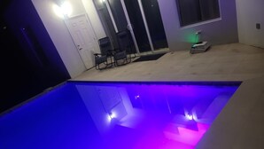 A swimming pool with a blue and purple light. - St. Rose Villa (Savannes)
