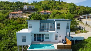A modern two-story house with a swimming pool, surrounded by lush greenery and hills. - St. Rose Villa (Savannes)