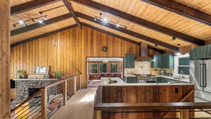 A spacious kitchen with wooden beams, a central island, and modern appliances.
