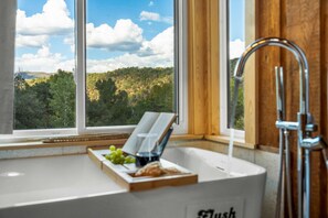 A bathroom with a window, a sink, and a shower.