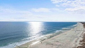 Une plage avec un ciel dégagé et une mer calme.