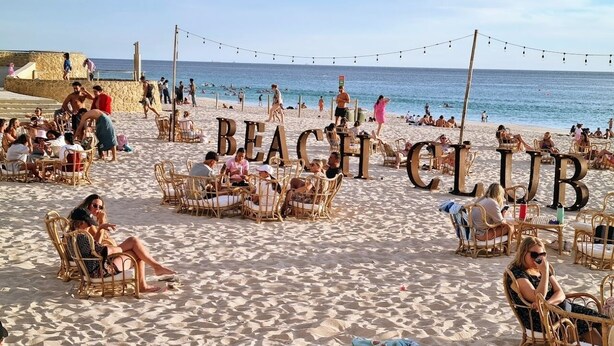 A beach club with wicker chairs and tables, a stone wall, and the ocean in the background. - Scarborough Beach Front Resort - Shell Thirteen (Scarborough)