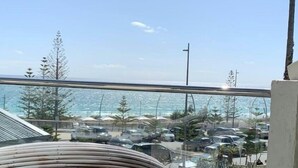 A view from a balcony overlooking a parking area with a beach and ocean in the background. - Scarborough Beach Front Resort - Shell Thirteen (Scarborough)