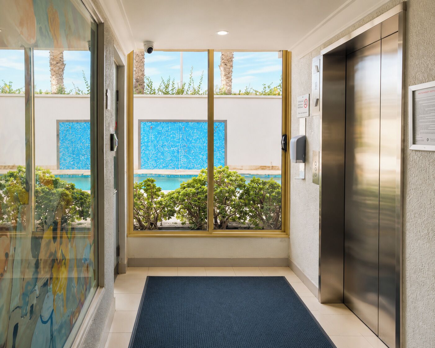 Un ascenseur offrant une vue sur une piscine et sur la verdure environnante.