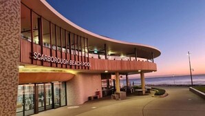 Un bâtiment à la façade incurvée, sur lequel on peut lire l’inscription « Scarborough Beach Pool ».