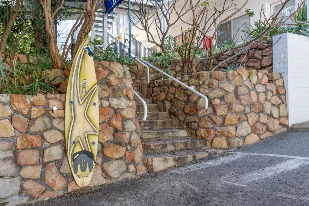 Uma escadaria de pedra leva a um edifício, com um caiaque encostado na parede.