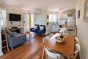 Ein modernes Apartment mit Wohnzimmer, Essbereich und Küche.