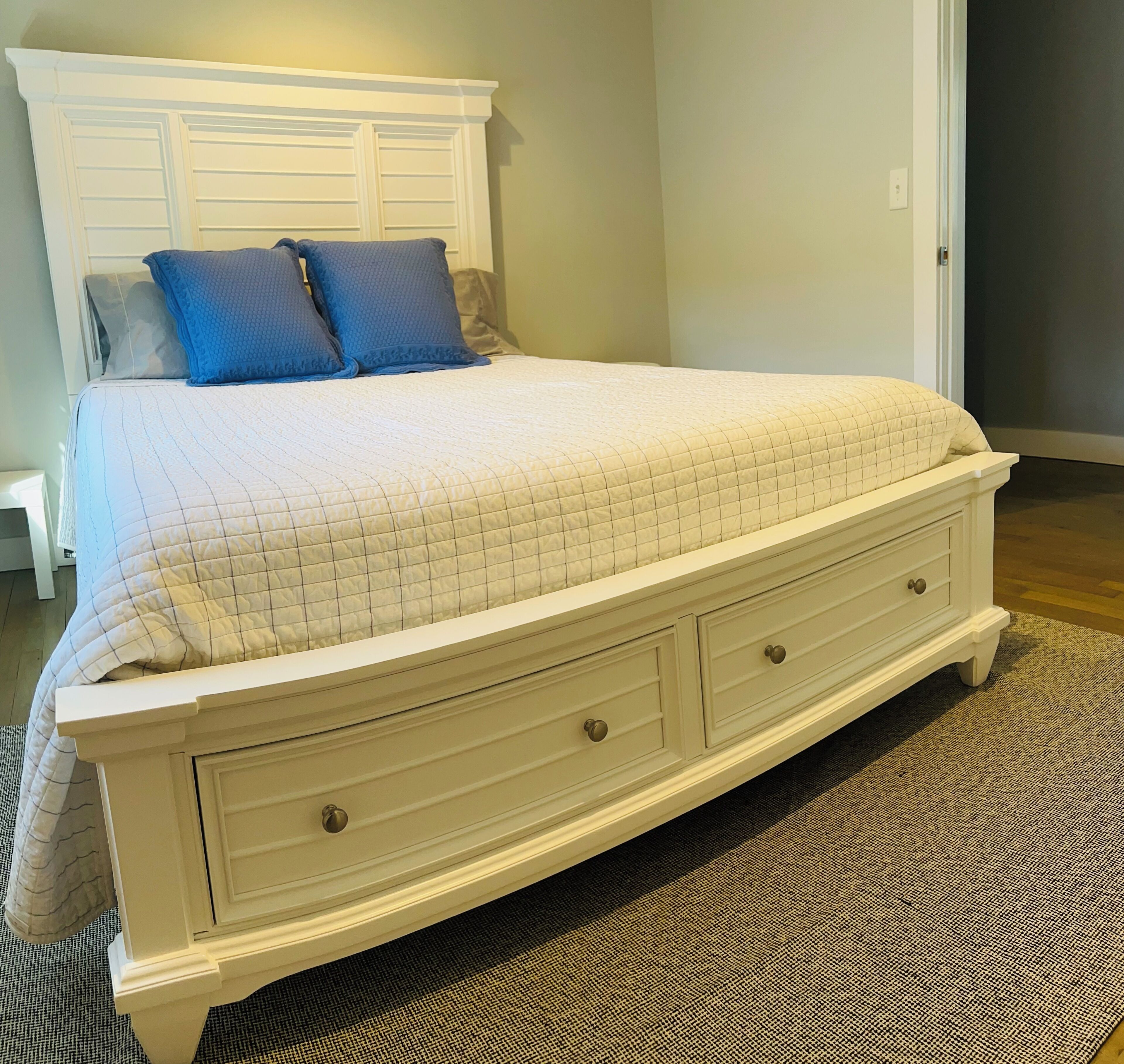 A bedroom with a bed, a nightstand, and a dresser.