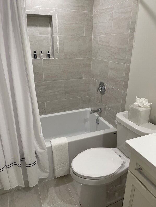 Un baño con bañera, inodoro y zona de ducha.