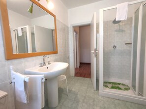 Une salle de bain avec un lavabo, un miroir et une douche.