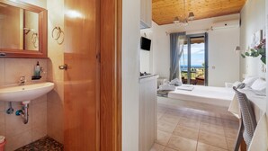 Un baño con lavamanos, espejo y puerta de madera.