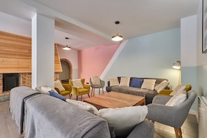 Un salon moderne avec une cheminée, des canapés, des fauteuils et une table basse.