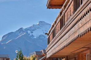 Un bâtiment en bois avec une montagne en arrière-plan.
