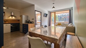 Una cocina moderna con comedor, suelo de madera y un ventanal con vistas.