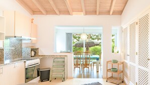 A modern kitchen with granite countertops, a built-in oven, and a dining area with a table and chairs. - Holiday Home 'Sobreirinho - Selão Da Eira' with Sea View, Shared Pool and Wi-Fi (São Teotónio)