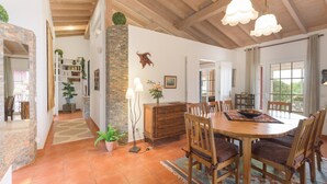 A dining area with a wooden table, chairs, and a chandelier. - Holiday Home 'Casa Alecrim - Selão Da Eira' with Sea View, Wi-Fi & Air Conditioning (S.Teotónio)