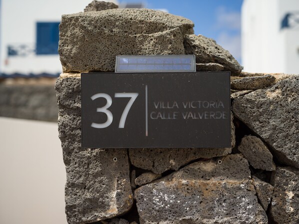 Senyal amb el número 37 i el text 'Villa Victoria Calle Valverde' fixat a una paret de pedra.