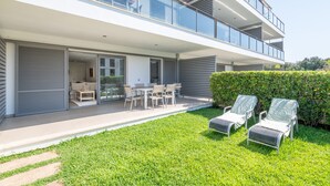 A modern two-story house with a balcony, outdoor seating, and a well-maintained lawn. - Apartment 'Boquer' with Shared Pool, 2 Private Terraces and Wi-Fi (Pollença)