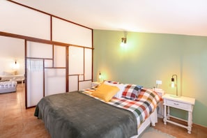Un dormitorio con cama, mesitas de noche, lámpara y armario.