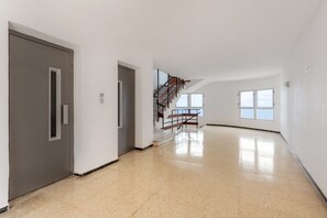 A spacious interior with a staircase, a door, and a window.