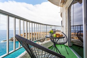 A balcony with a view of the ocean, a table with chairs, and a potted plant. - Holiday Apartment 'Vista Al Mar' with Sea View, Private Garden and Wi-Fi (Icod de los Vinos)