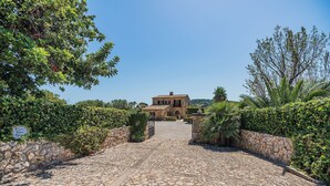 A stone pathway leading to a building surrounded by greenery. - Villa 'Toni Mosca' with Mountain View, Wi-Fi and Air Conditioning (Pollensa / Pollença)
