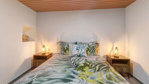 Una camera da letto con un letto, una testiera in legno, comodini e lampade a parete.