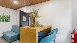Una stanza con una scrivania in legno, un divano blu e una poltrona blu.
