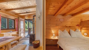 L’intérieur d’un chalet en bois comprend un coin repas, un lit recouvert d’une courtepointe blanche et une vue sur l’extérieur par une fenêtre.