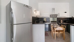 A compact kitchen with a refrigerator, stove, microwave, and dining table with chairs. - Studio Apartment 'Da Linda' with Mountain View and Wi-Fi (Cisano sul neva)