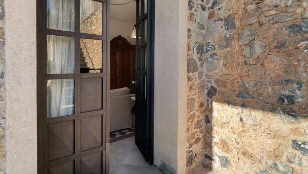 A stone wall, a wooden door, and a tiled floor. - Studio Apartment 'Da Linda' with Mountain View and Wi-Fi (Cisano sul neva)
