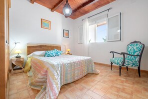 A bedroom with a bed, a chair, a window, and a ceiling light. - Country House 'Caseta Montanyana' with Private Terrace, Private Garden and Wi-Fi (Deltebre)
