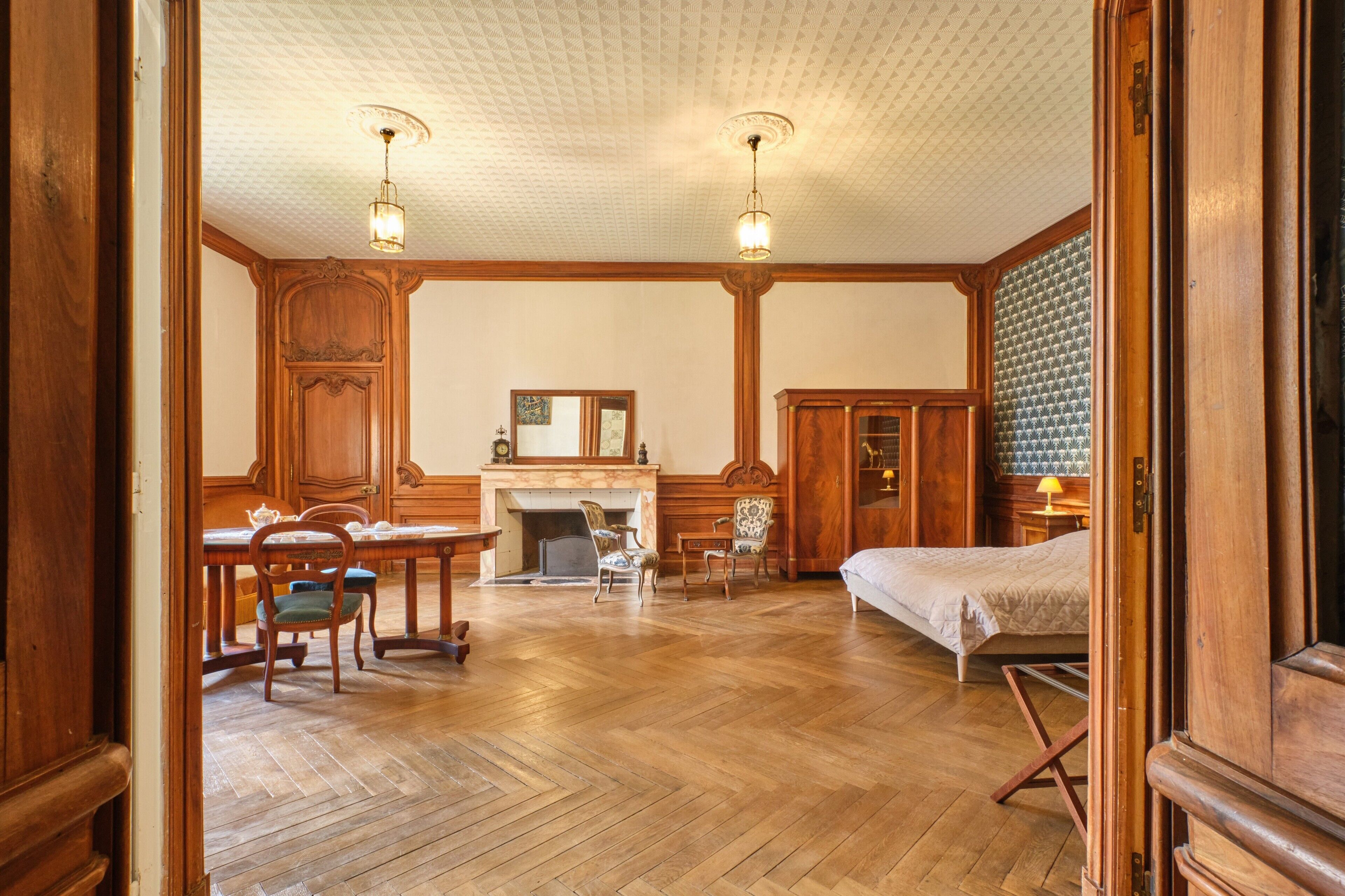 Une pièce avec une cheminée, des meubles en bois et un lit.
