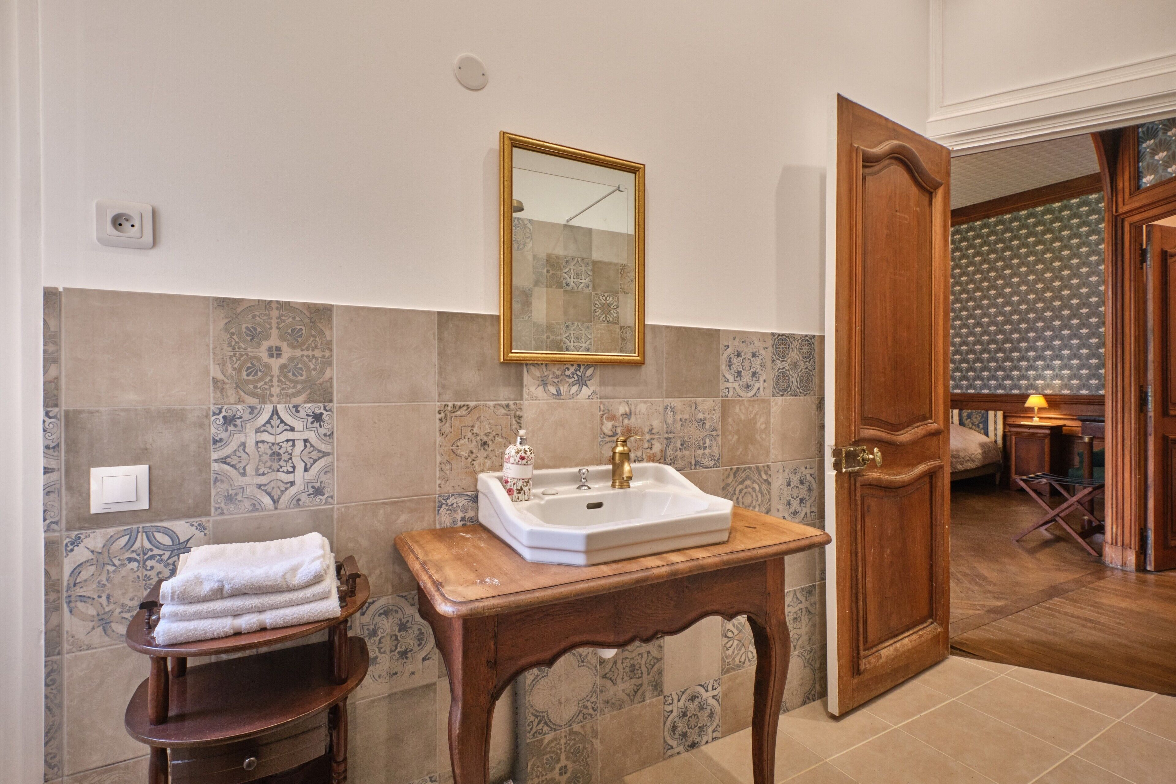 Un bagno con lavandino, specchio e porta asciugamani.