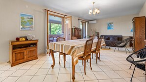 Un comedor con una mesa, sillas, un armario y un sofá.