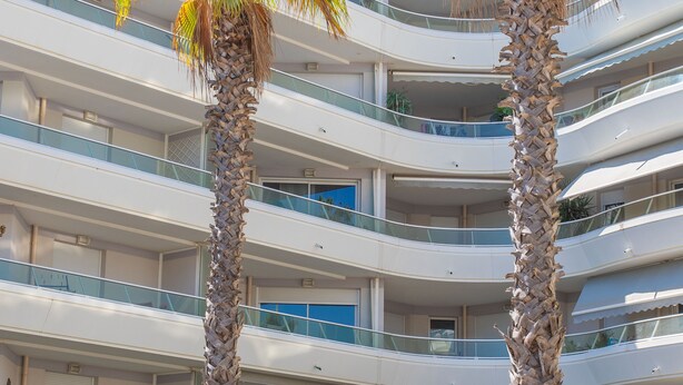 A multi-story building with balconies, palm trees, and a clear sky. - Apartment 'Superbe Appartement Vue Mer' with Sea View, Wi-Fi and Air Conditioning (Fréjus)