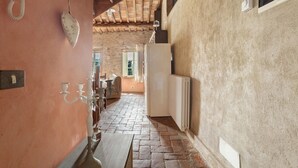 A narrow hallway with a rustic ceiling, a white radiator, and a door leading to another room. - Apartment 'Appartamento Torre' with Shared Pool, Shared Garden and Wi-Fi (Massarosa)