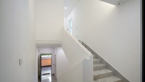 Eine Treppe mit weißen Wänden und Marmorstufen, die zu einer oberen Etage führt.